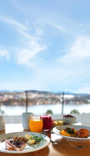 a table with two plates of food and orange juice at Kragerø Resort in Kragerø