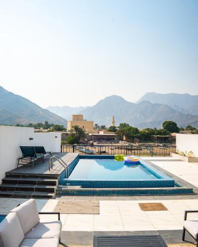 a pool on the roof of a house with mountains in the background at 3BR villa and maid room by escape time in Sharm
