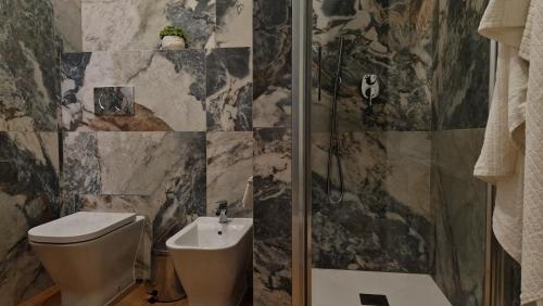 a bathroom with a shower and a toilet and a sink at La Maison del Duomo in Catania