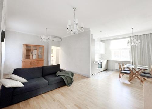 a living room with a black couch and a table at City heart, space, loft view, free parking in Rīga