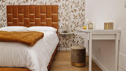 a bedroom with a bed with a wooden headboard and a table at La Maison del Duomo in Catania