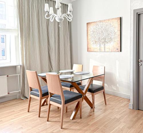 a dining room table with chairs and a chandelier at City heart, space, loft view, free parking in Rīga