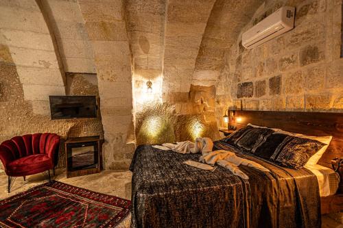 een slaapkamer met een groot bed in een stenen muur bij Zümrütü anka cave in Urgup