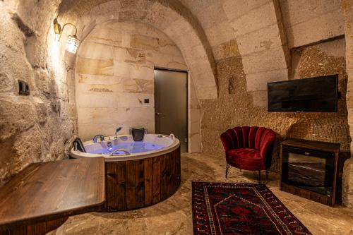 een badkamer met een bad en een stoel bij Zümrütü anka cave in Urgup