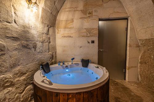 a bathroom with a large tub in a stone wall at Zümrütü Anka Cave in Ürgüp