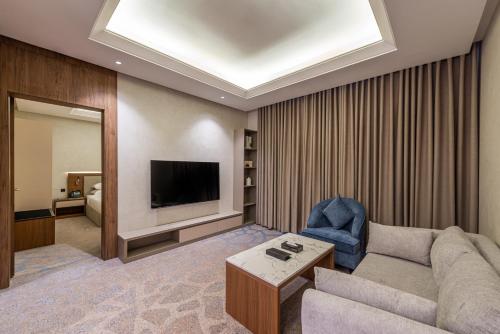 a living room with a couch and a television at Voyage Hotel & Suites in Riyadh