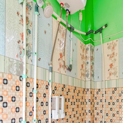 baño con ducha con azulejos en la pared en Hotel Pabelan RedPartner, en Bengkulu