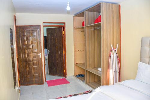 a bedroom with a bed and a room with a closet at Ligen Suites in Kakamega