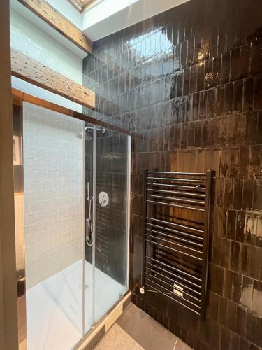 une douche avec une porte vitrée dans une salle de bain dans l'établissement Saint Jacques Disney, à Paris