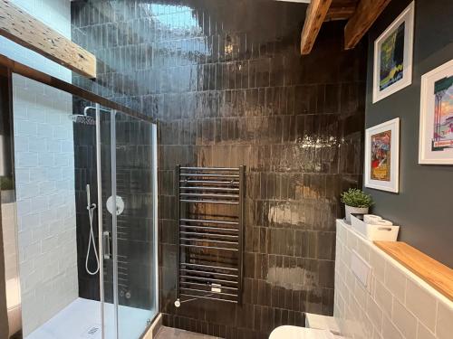 La salle de bains est pourvue d'une cabine de douche en verre. dans l'établissement Saint Jacques Disney, à Paris