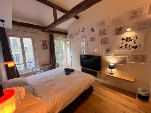 une chambre avec un lit et une télévision à écran plat dans l'établissement Saint Jacques Disney, à Paris