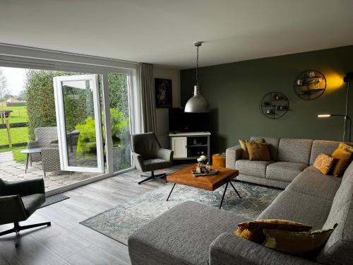 a living room with a couch and a table at Vakantiewoning Le Garaazje in 's-Gravendeel