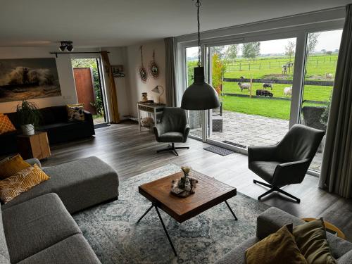 a living room with a couch and chairs and a table at Vakantiewoning Le Garaazje in 's-Gravendeel