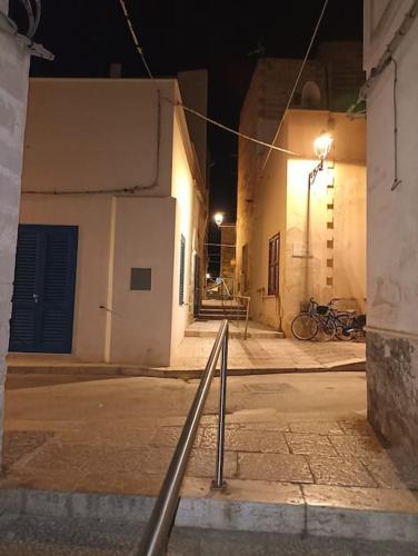 an empty street at night with buildings and bikes at La Casa del Moro in Favignana