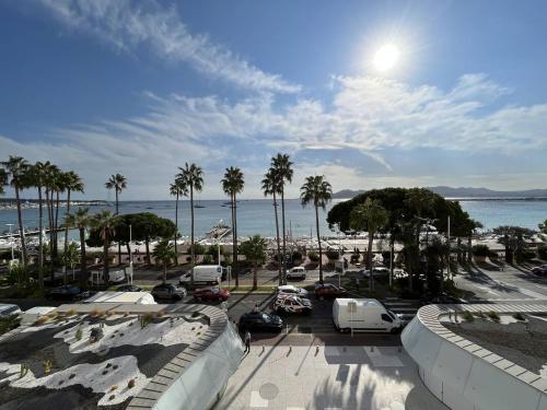 - une vue sur un parking avec des palmiers et l'océan dans l'établissement 204 - Cannes La Croisette - Studio face mer avec balcon, à Cannes