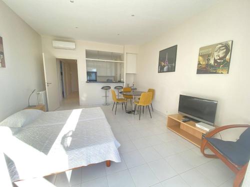 Cette chambre comprend un lit, une télévision et une table. dans l'établissement 204 - Cannes La Croisette - Studio face mer avec balcon, à Cannes