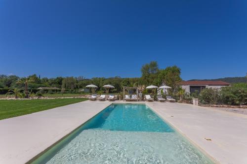 a swimming pool with chairs and umbrellas in a yard at Domaine Montserrat in Le Luc