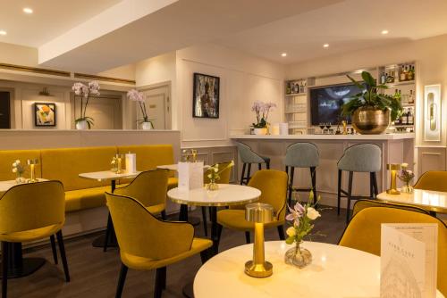 un restaurant avec des tables et des chaises et un bar dans l'établissement Hotel Park Lane Paris, à Paris