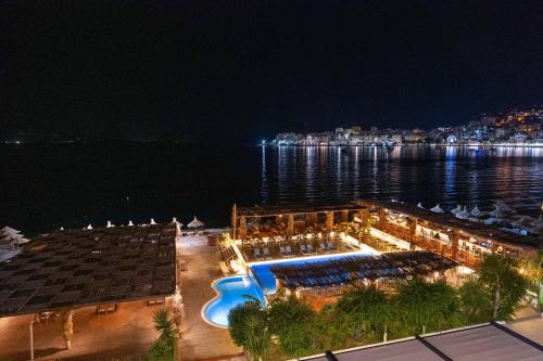 a resort on the water at night at Grand Hotel Saranda in Sarandë