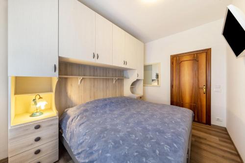 a small bedroom with a bed and white cabinets at Casa Da Rin Elena in Auronzo di Cadore