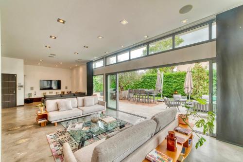 un salon avec un canapé et une table en verre dans l'établissement L'Avedis - Magnifique maison de luxe avec piscine, à Montanay