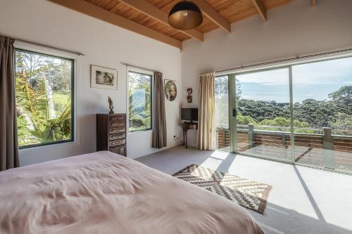 a bedroom with a bed and a large window at Seaview Sanctuary in Onetangi