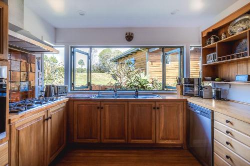 a kitchen with wooden cabinets and a large window at Seaview Sanctuary in Onetangi