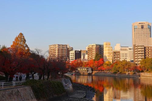 a city with buildings and a river with fall foliage at Rihga Royal Hotel Hiroshima in Hiroshima