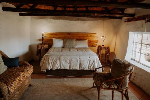 a bedroom with a bed and a chair and a window at Harmony Game Lodge in Middlerus