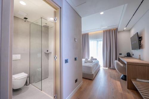 a bathroom with a toilet and a glass shower at Grand Hotel Saranda in Sarandë