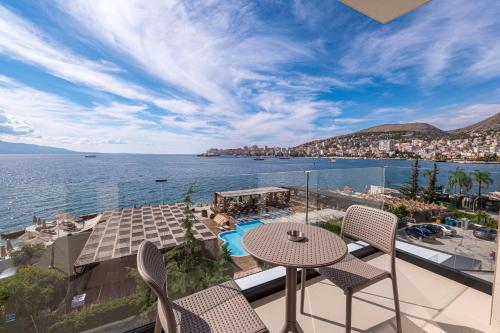 a balcony with a table and chairs and a view of the water at Grand Hotel Saranda in Sarandë