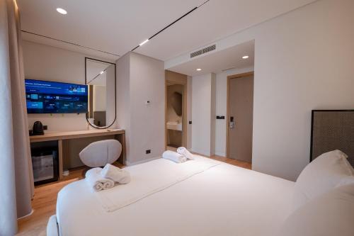 a bedroom with a large white bed and a desk at Grand Hotel Saranda in Sarandë
