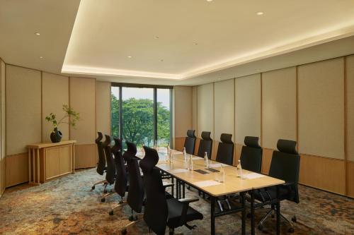 a conference room with a long table and chairs at Hotel Tentrem Jakarta in Serpong