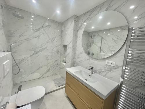 une salle de bain blanche avec un lavabo et un miroir dans l'établissement Verdalia luxury 3 bedroom by Welcome to Cannes, à Cannes
