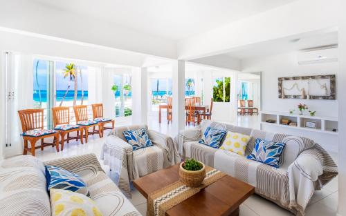 a living room with couches and a table at Prime Ocean View Punta Cana Apartments - 3-Bedroom Getaway with Private Terrace on Bávaro Beach in Punta Cana