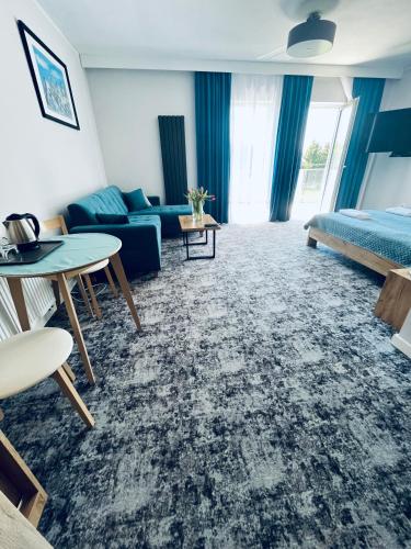 a hotel room with a bed and a couch and a table at La Park Aparthotel in Kudowa-Zdrój