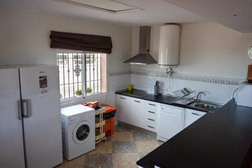 eine Küche mit einem weißen Kühlschrank und einer Waschmaschine in der Unterkunft Casa Martina in La Carlota