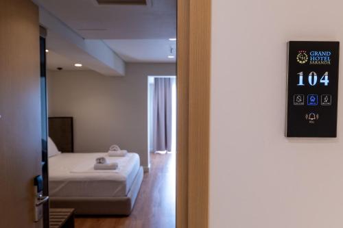 a room with a bed and a clock on the wall at Grand Hotel Saranda in Sarandë