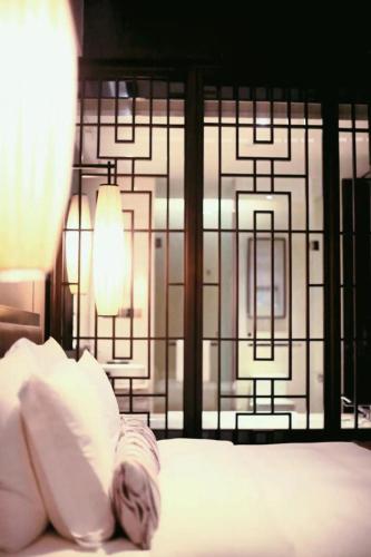 a bed with white pillows and a window with lights at Crowne Plaza Chongqing New North Zone by IHG in Chongqing