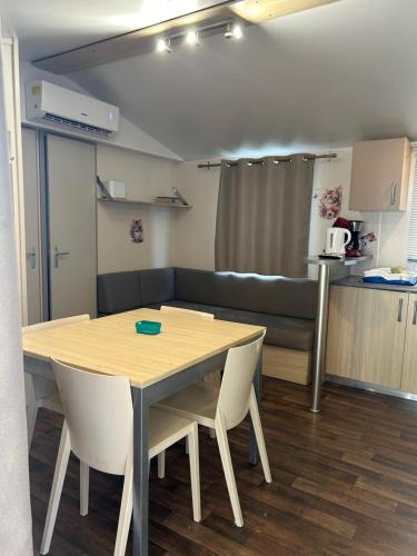 a room with a table and chairs and a couch at Chez Nathalie mobil home chauffé et climatisé in Boofzheim