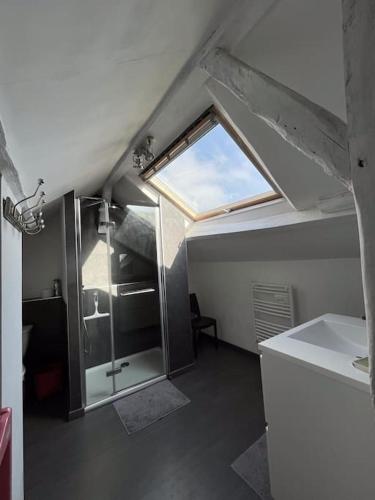 La salle de bains est pourvue d'une douche en verre et d'une fenêtre. dans l'établissement Demeure spacieuse avec piscine dans le Perche, à La Veronnière