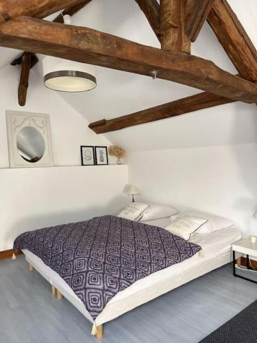 une chambre avec un grand lit dans une pièce dans l'établissement Demeure spacieuse avec piscine dans le Perche, à La Veronnière