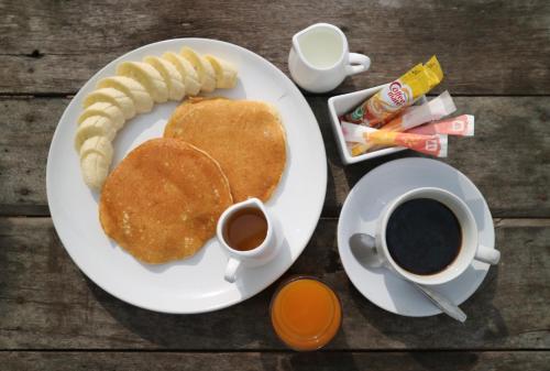 Cottage Hill at Lanta في كو لانتا: طبق من الفطائر والقهوة على طاولة خشبية