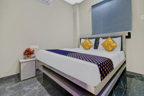 a bedroom with a bed with yellow and blue pillows at Hotel O The VNP Inn in Sakardarā
