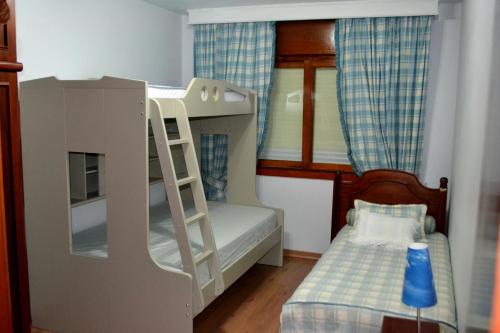 Dormitorio infantil con litera y escalera en Apartamento Central, en Gramado