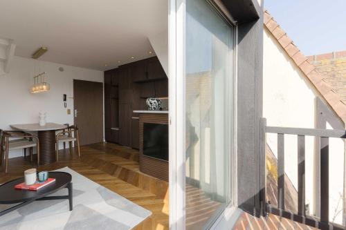 - un salon avec vue sur une cuisine et une salle à manger dans l'établissement High-end 2 bedroom duplex with parking Place Morny, à Deauville