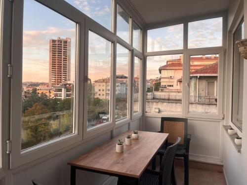 a table and chairs in a room with windows at Spacious flat with wide view in Istanbul