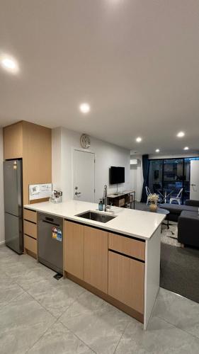 a kitchen with a sink and a living room at Close to City and Beach - Modern Home with Garage in Christchurch