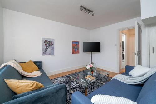 a living room with two blue couches and a tv at New 4BD Stylish Apartment with Amazing Transport in London