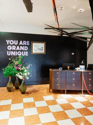 an office with a black wall and vases with flowers at Grand Hôtel Wiesler - Centre of Graz in Graz